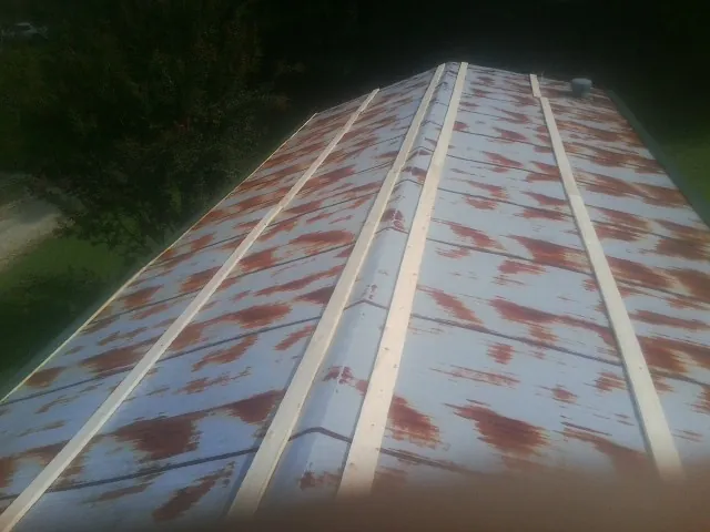 Rusted metal roof panels with new wood purlins before replacement — Storm Damage Roof Repair in Harpster by Roofing Brothers